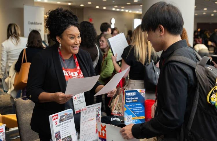 A recruiter excitedly discusses job prospects at the Career Fair during the NRF Foundation Student Program